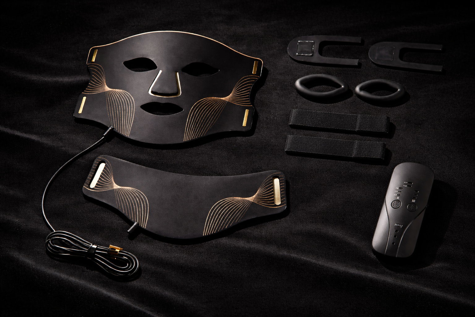 Aura Mask flat lay on black velvet showing face mask, neck attachment, handheld remote controller, charging cable, straps and accessories — Healing Circle